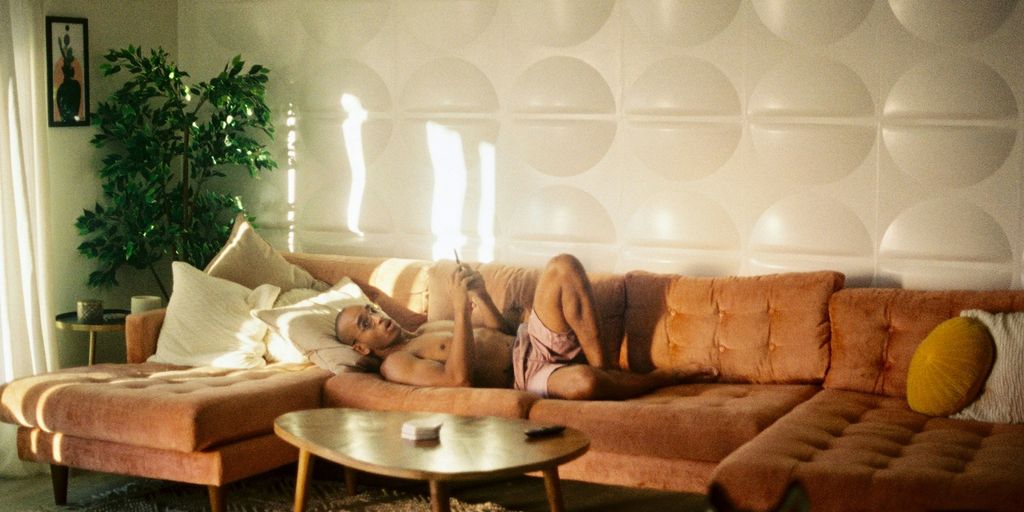 Someone is lounging on a comfy orange couch.