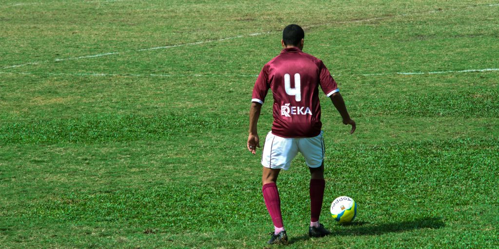 man in blue and white nike jersey shirt and white shorts playing soccer on green grass