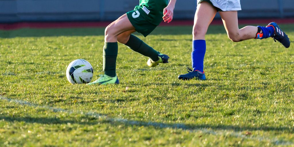 a couple of kids playing a game of soccer