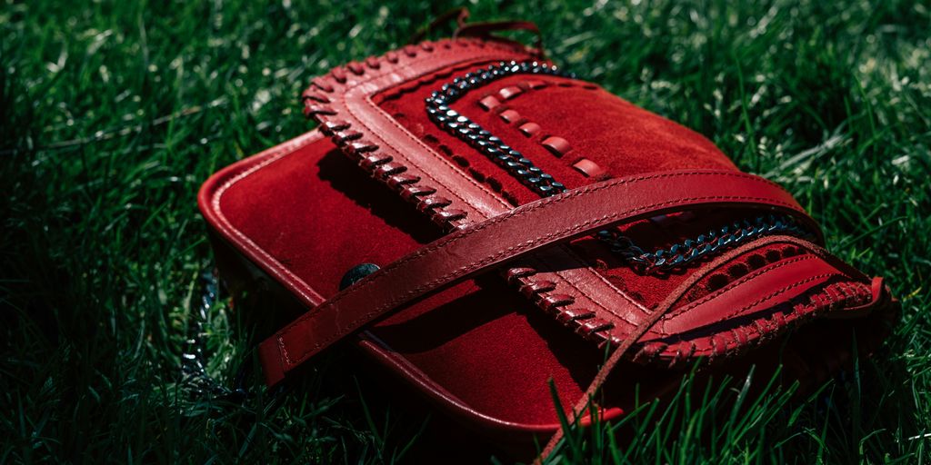 red leather handbag on grasses