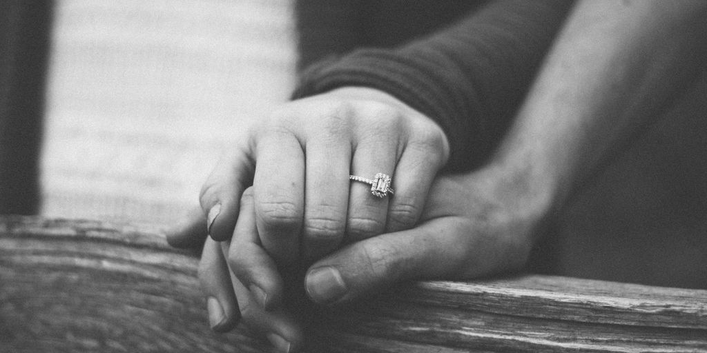 a couple holding hands with a wedding ring visible