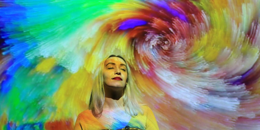 a woman standing in front of a colorful background