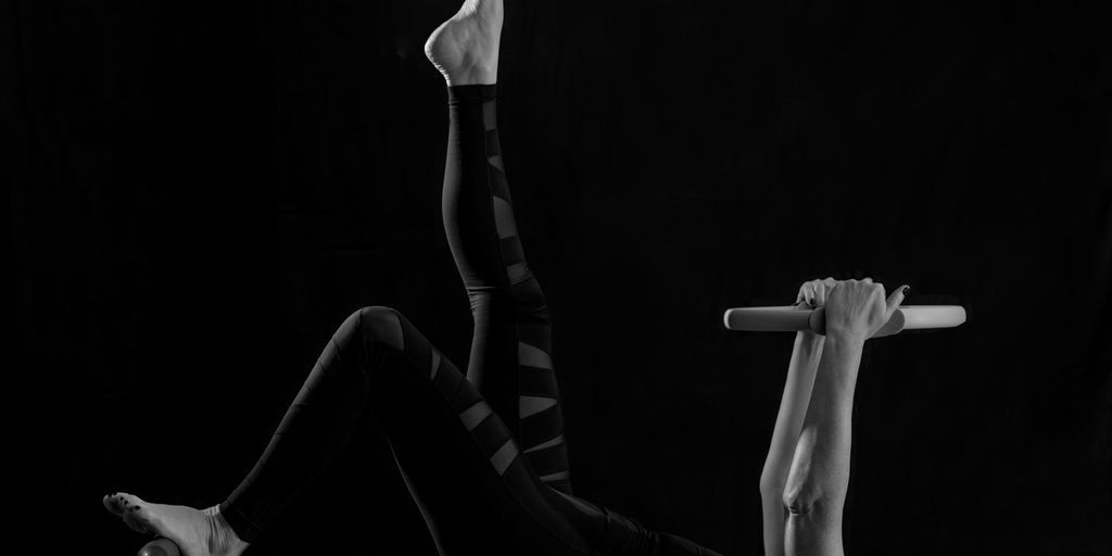 woman in black pants and black boots lying on black wooden bench