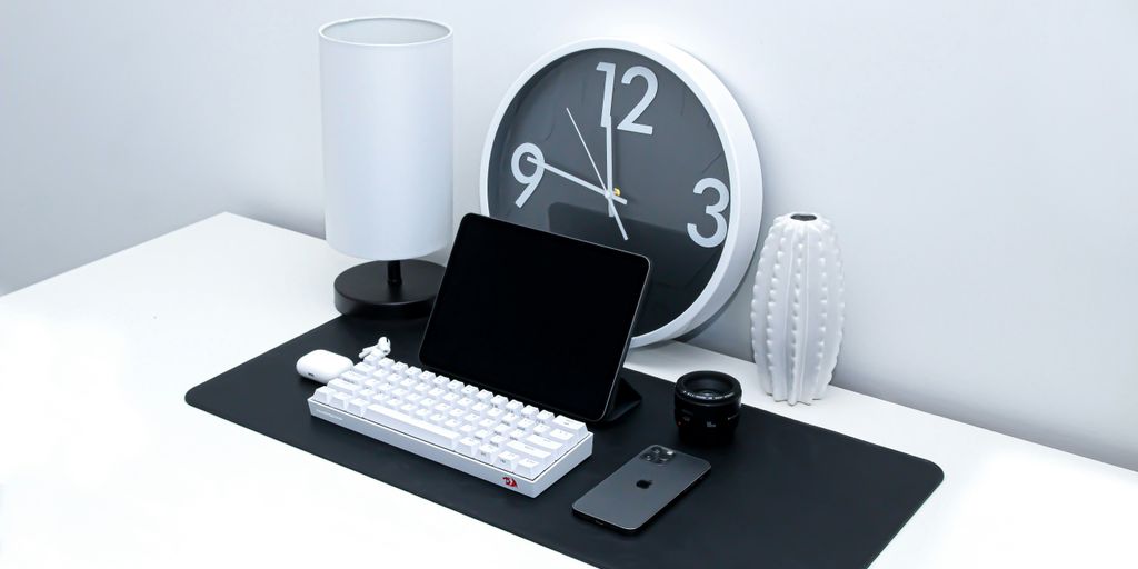 black ipad and white keyboard on black table