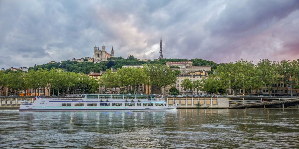 a river boat on a river with a city in the background