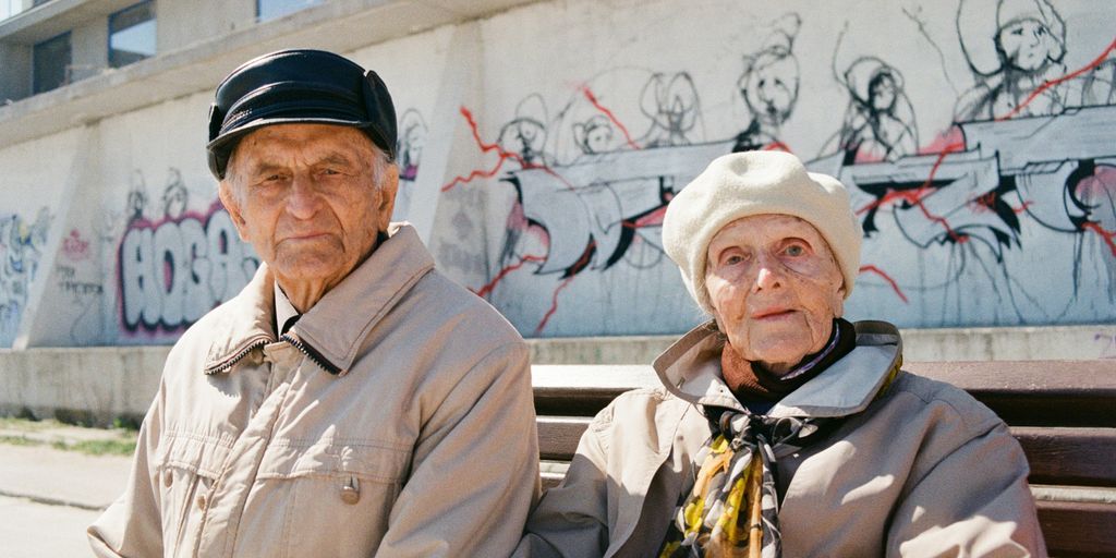 a man and woman standing in front of a wall with graffiti
