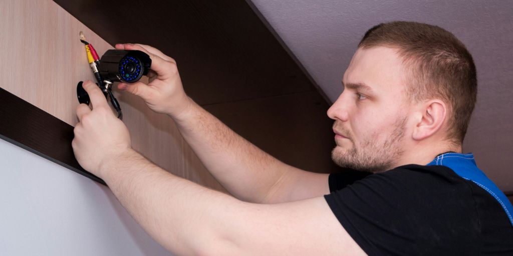 a man working on a wall with a screwdriver