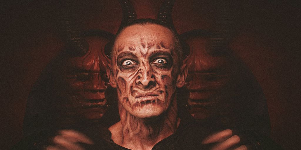 a man with a devilish face and horns on his head