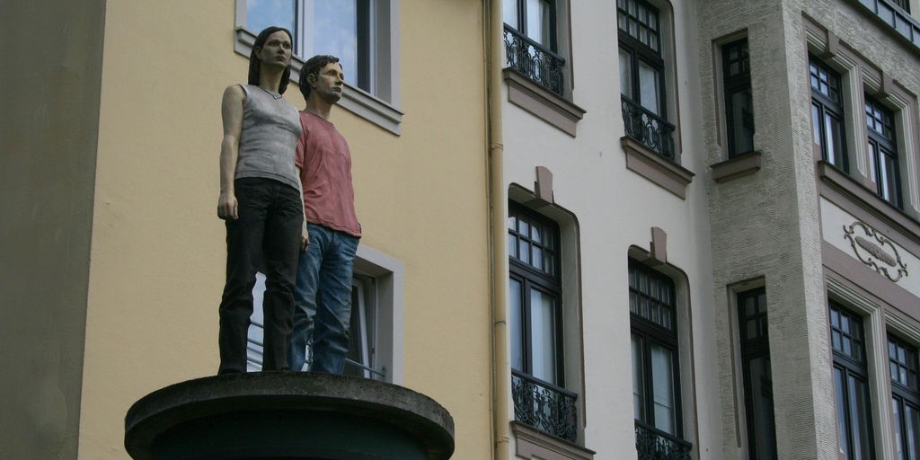 a couple of people standing on top of a statue