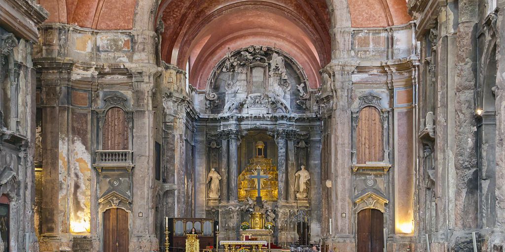 Inside a grand, historical church, viewed from the pews.