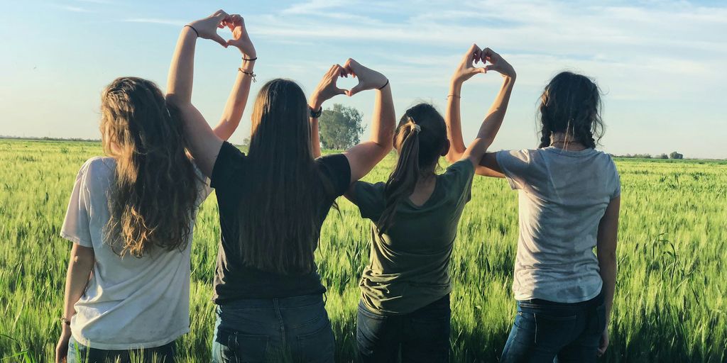 women forming heart gestures during daytime
