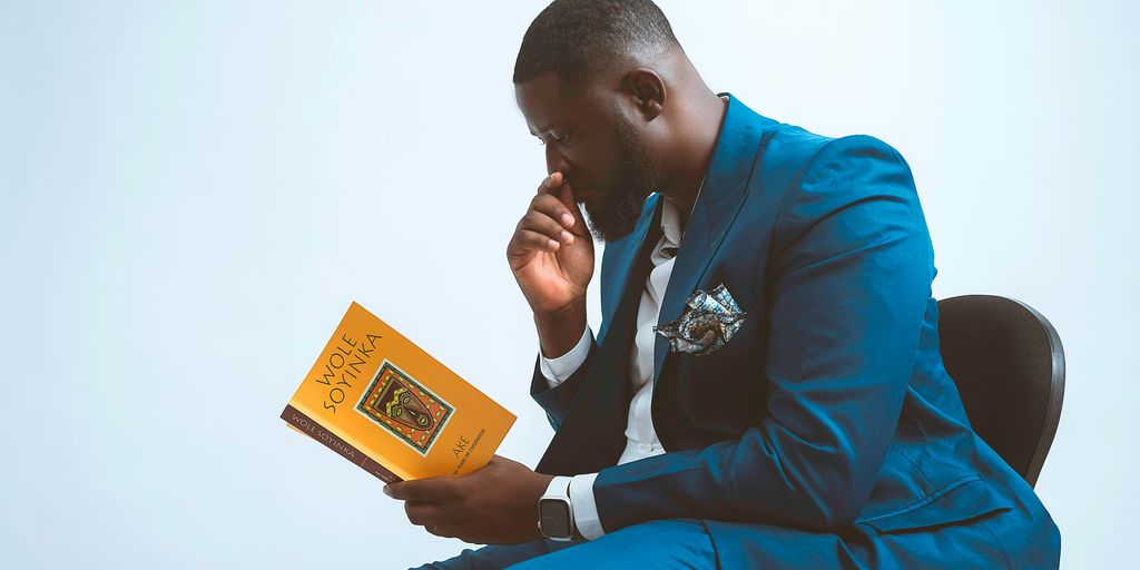 a man in a blue suit is reading a book