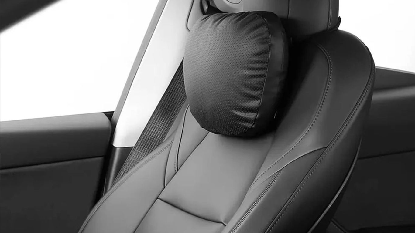 A sleek car seat with a neck pillow for comfort.