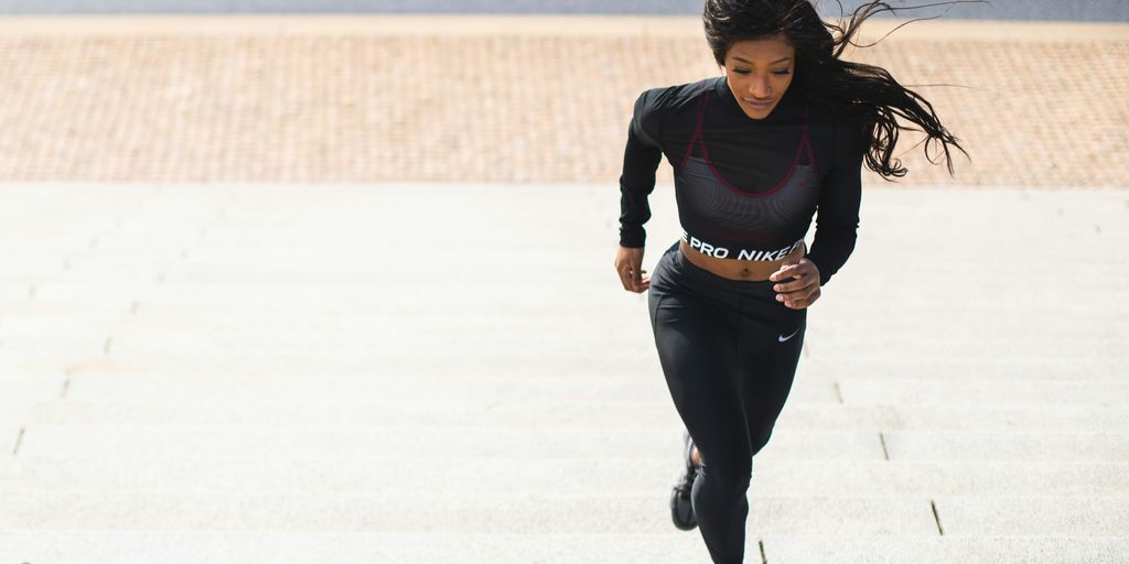 woman in black long sleeve shirt and black pants running on gray concrete road during daytime