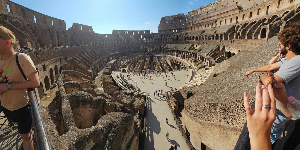 A man and a woman taking a picture of a roman colossion