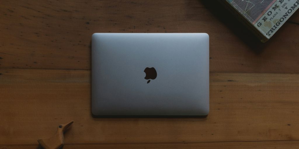 silver MacBook on brown wooden table