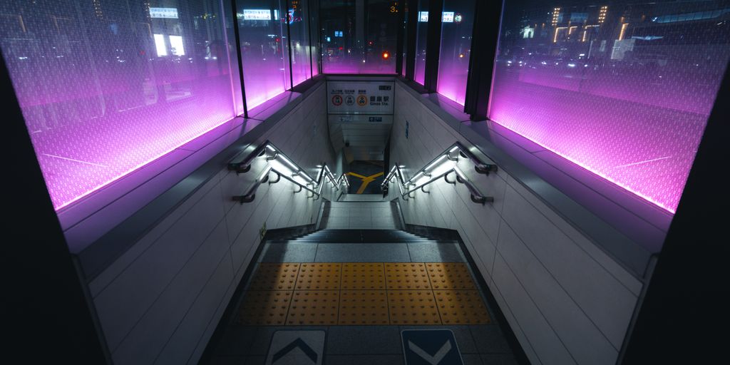 A train station with purple lights on the walls