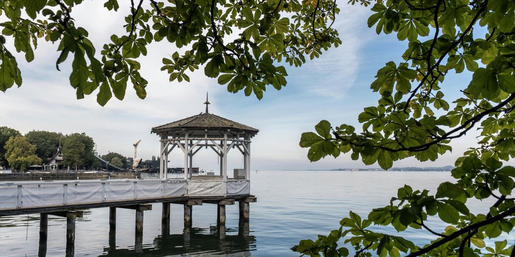 a gazebo sitting on top of a pier next to a body of water