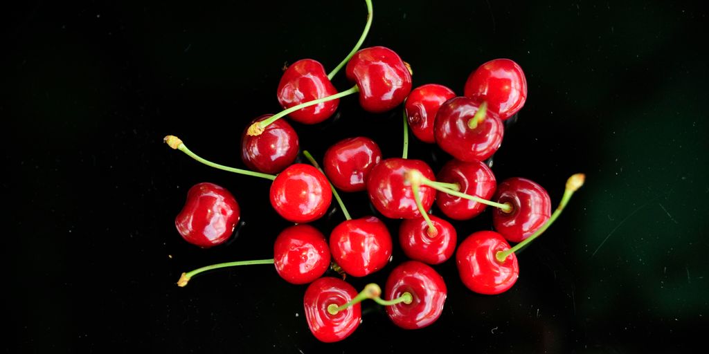 a bunch of red cherries sitting on top of a table