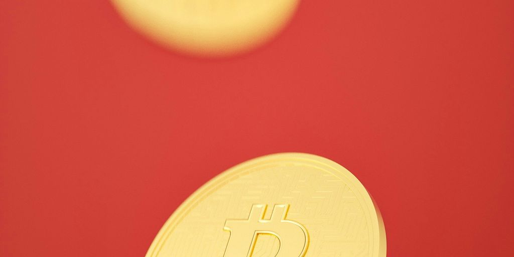 Golden Bitcoin coins falling against a red background.