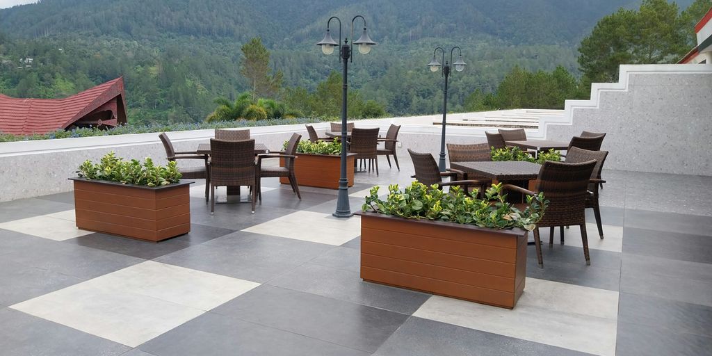 a patio with tables and chairs and a view of mountains
