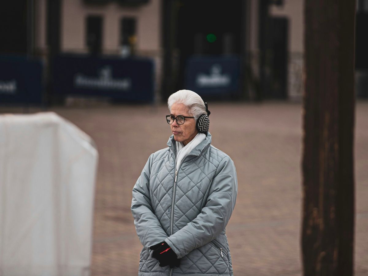 woman wearing earmuffs and quilted gray jacket