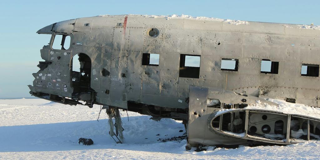 white and black airplane on snow covered ground during daytime