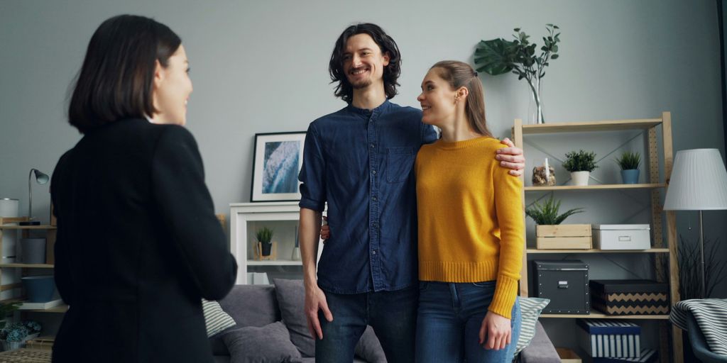 a man and two women standing in a living room