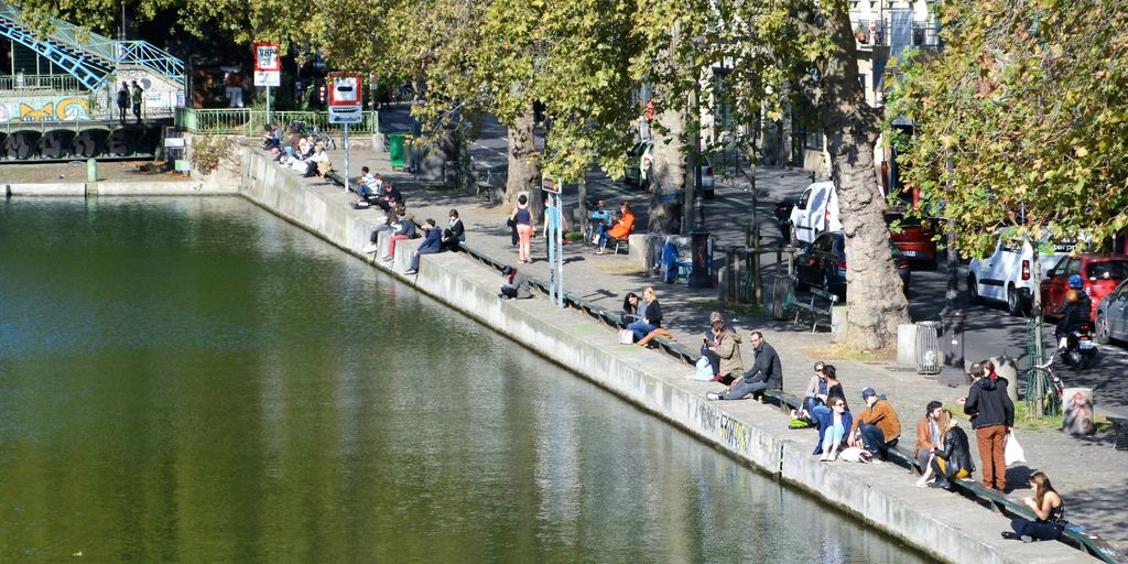 people walking on sidewalk near river during daytime