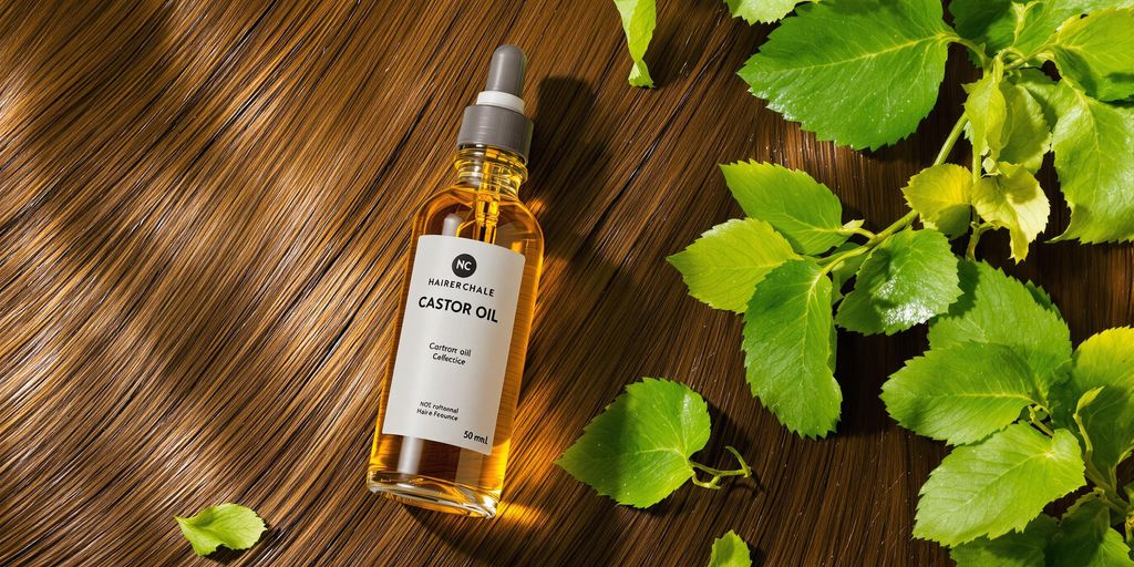 Bottle of castor oil with leaves and smooth hair.