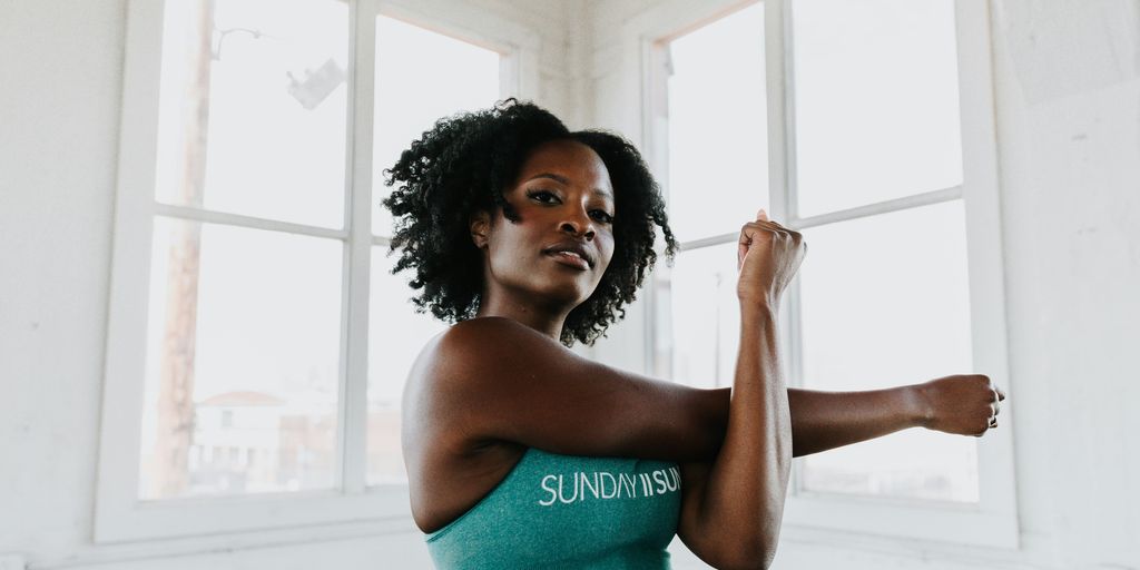 a woman in a sports bra top stretching her arms