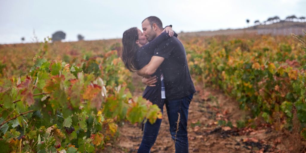 a man and a woman kissing in a field
