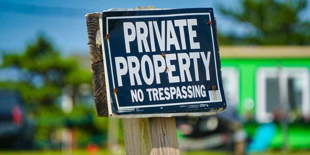 a private property sign posted on a wooden post