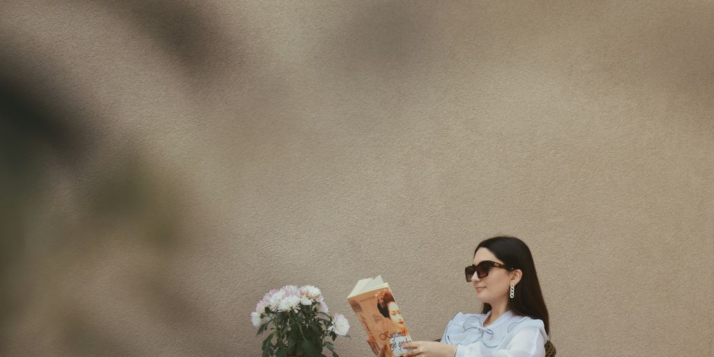 a person sitting at a table reading a book