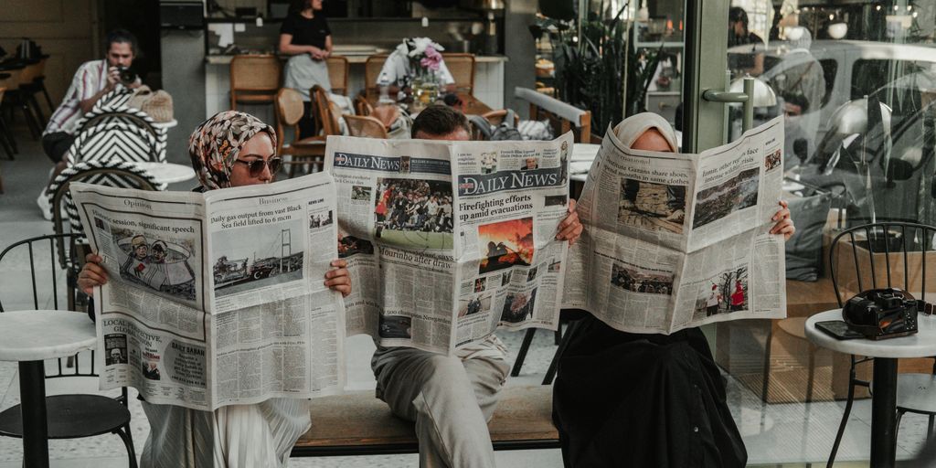 A man sitting on a bench reading a newspaper