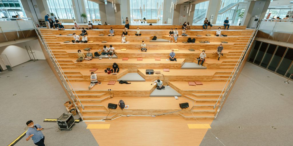 a group of people sitting on the floor in a large room