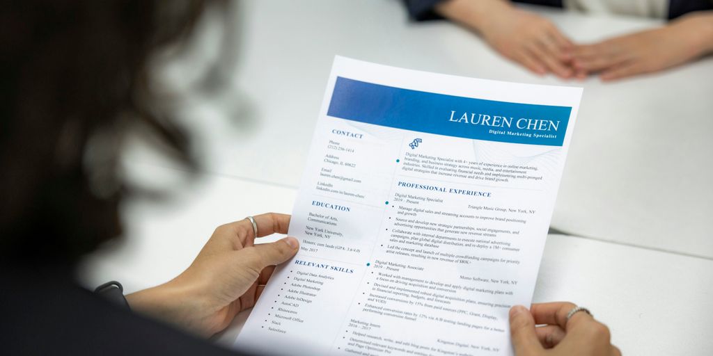 a woman is reading a resume at a table