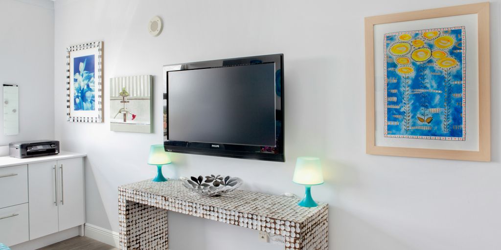 black flat screen tv on white wooden tv rack