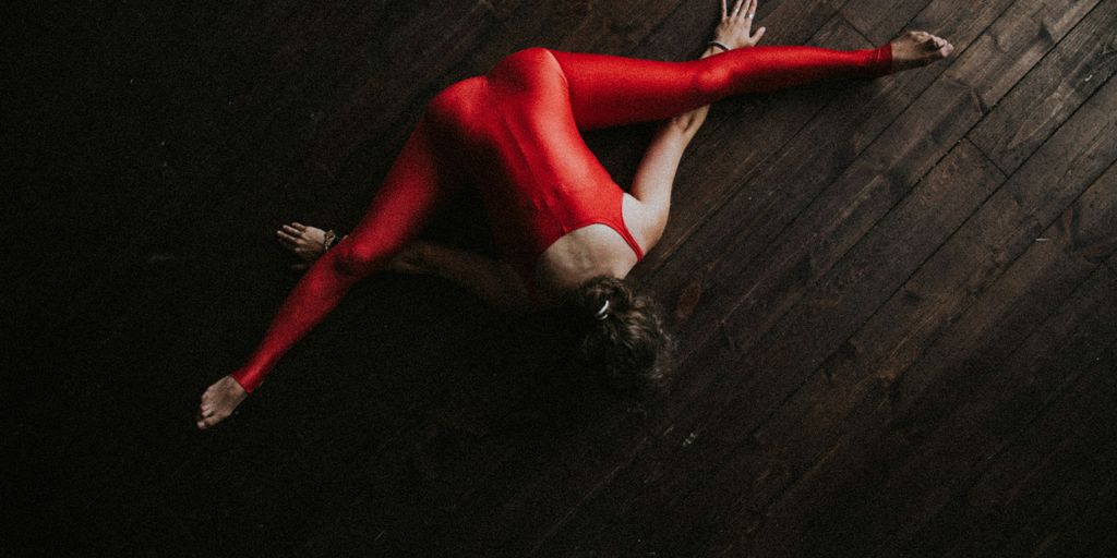 woman splitting and lying forward on parquet floor