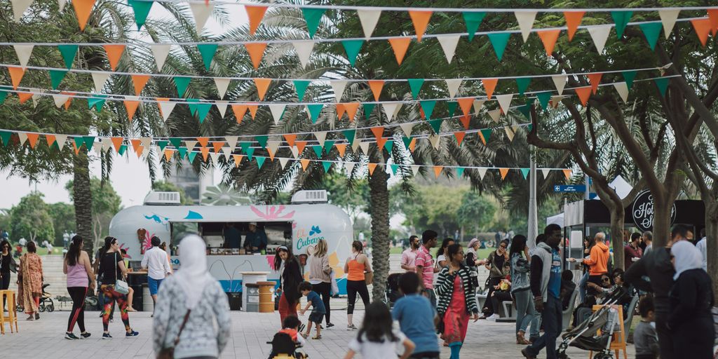 a crowd of people standing around a food truck