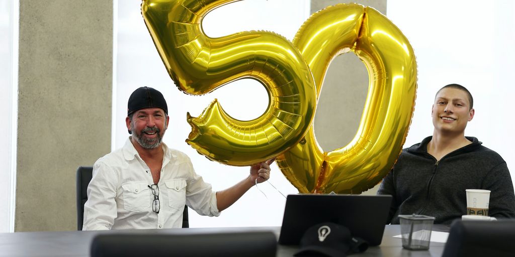 a man and a woman sitting at a table with a large balloon in the shape
