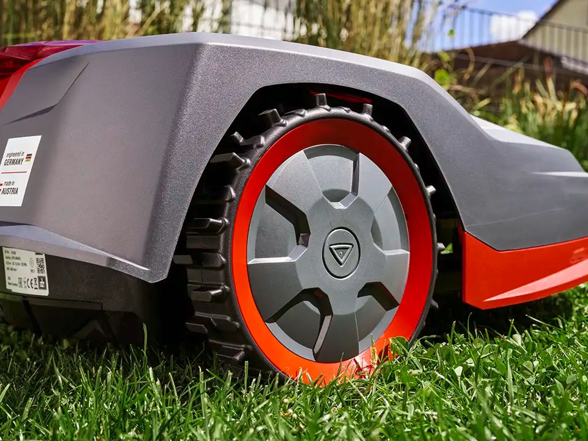 A close-up of a robotic lawn mower on grass.
