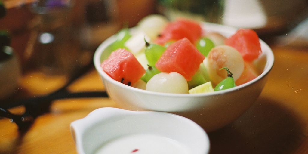 macro photography of sliced watermelon, lychee, and green grapes fruit in round white bowl