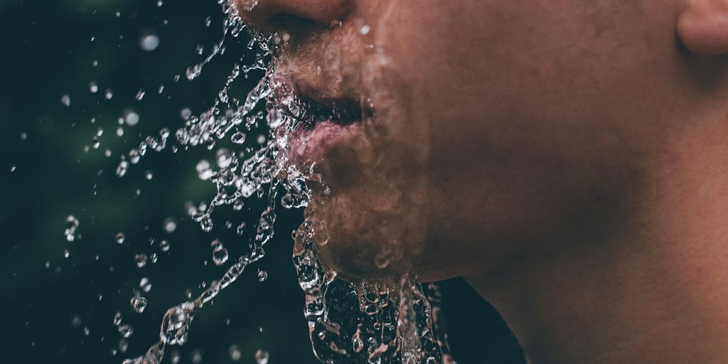 man face with water droplets