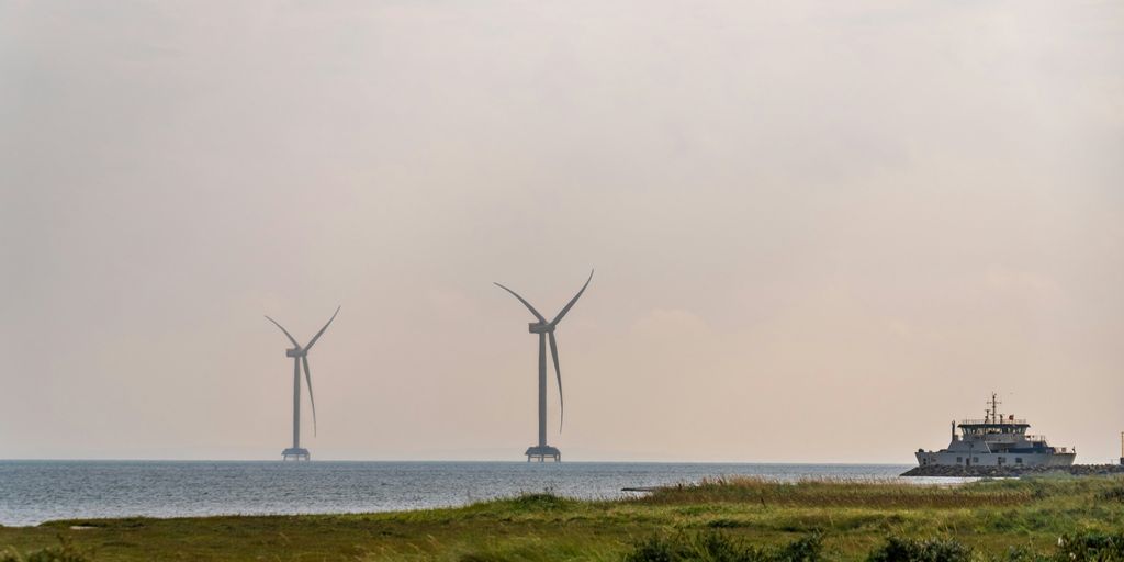 A group of windmills sitting on top of a lush green field