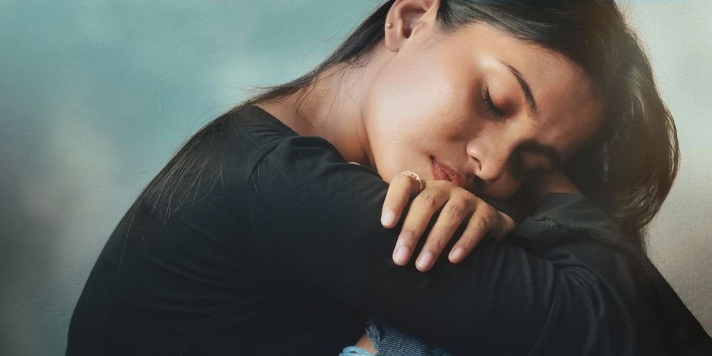 a woman sitting on a couch with her head on her hand