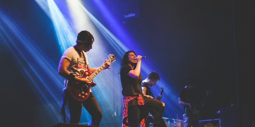 photo of male band performing on stadium
