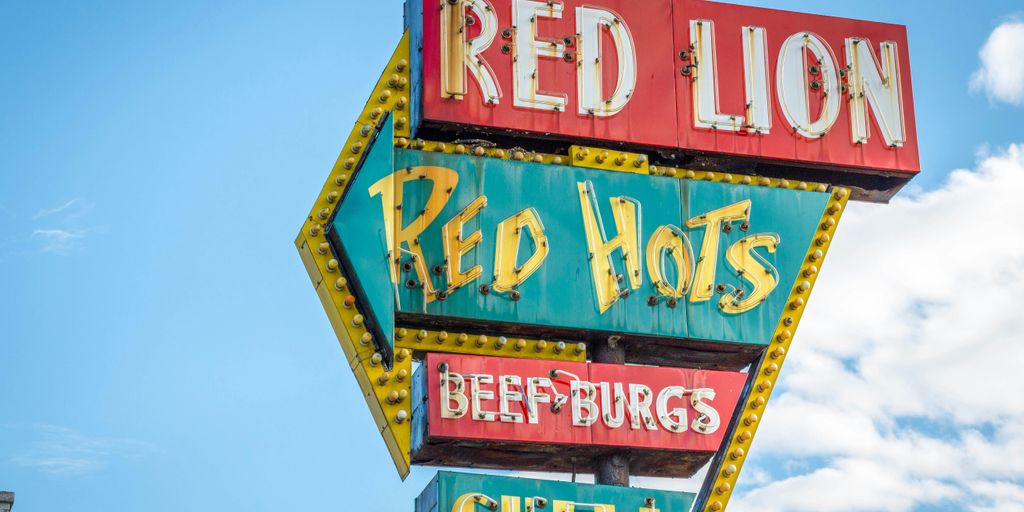 Red Lion, Red Hots, Beef Burgs, and Chili signage under white and blue cloudy skies