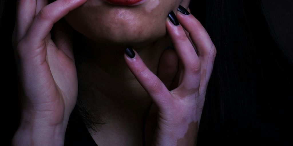 a woman with black nails and red lipstick