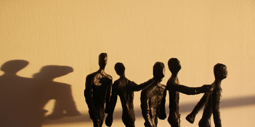 a shadow of a group of people holding hands